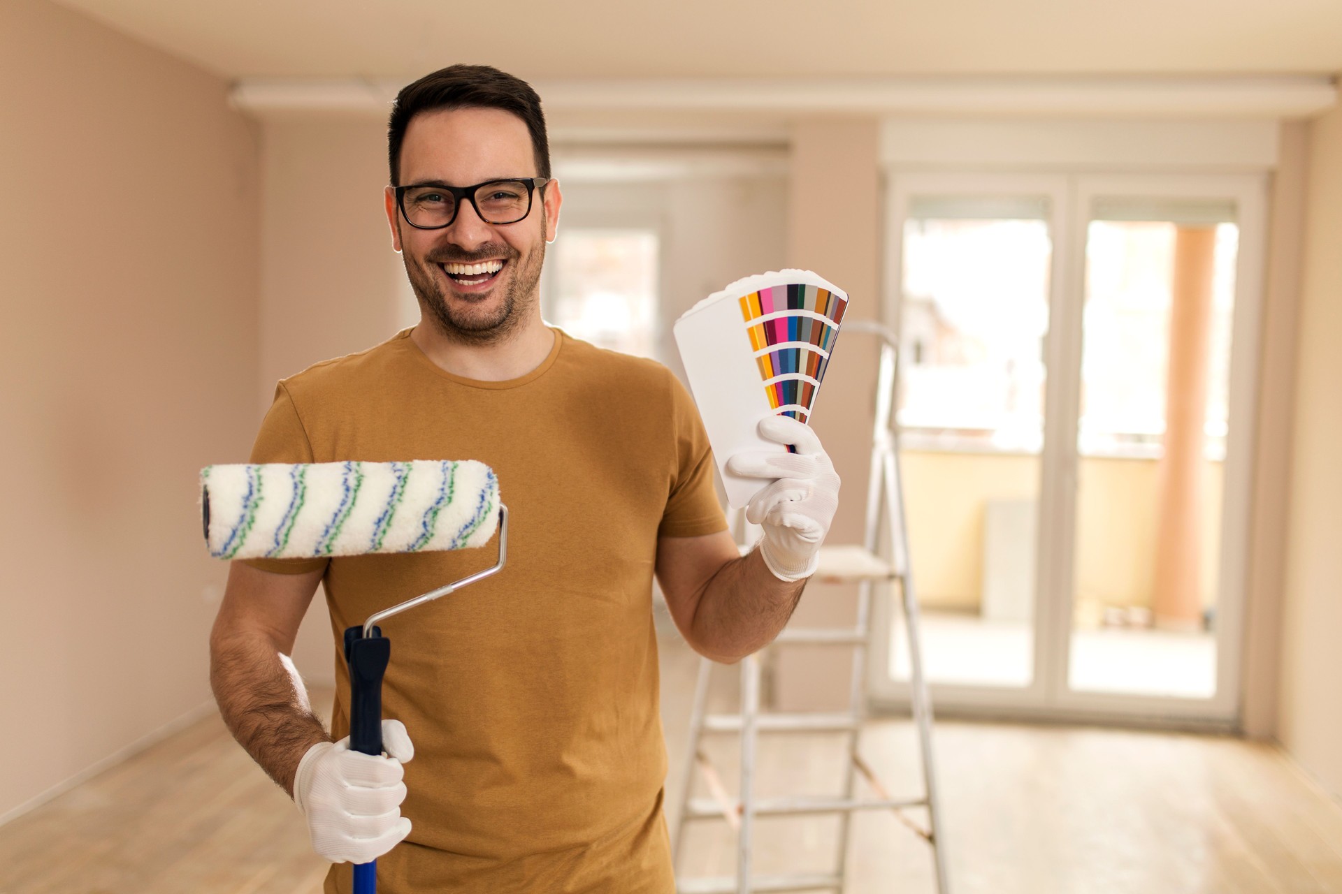 Young man painting apartment.